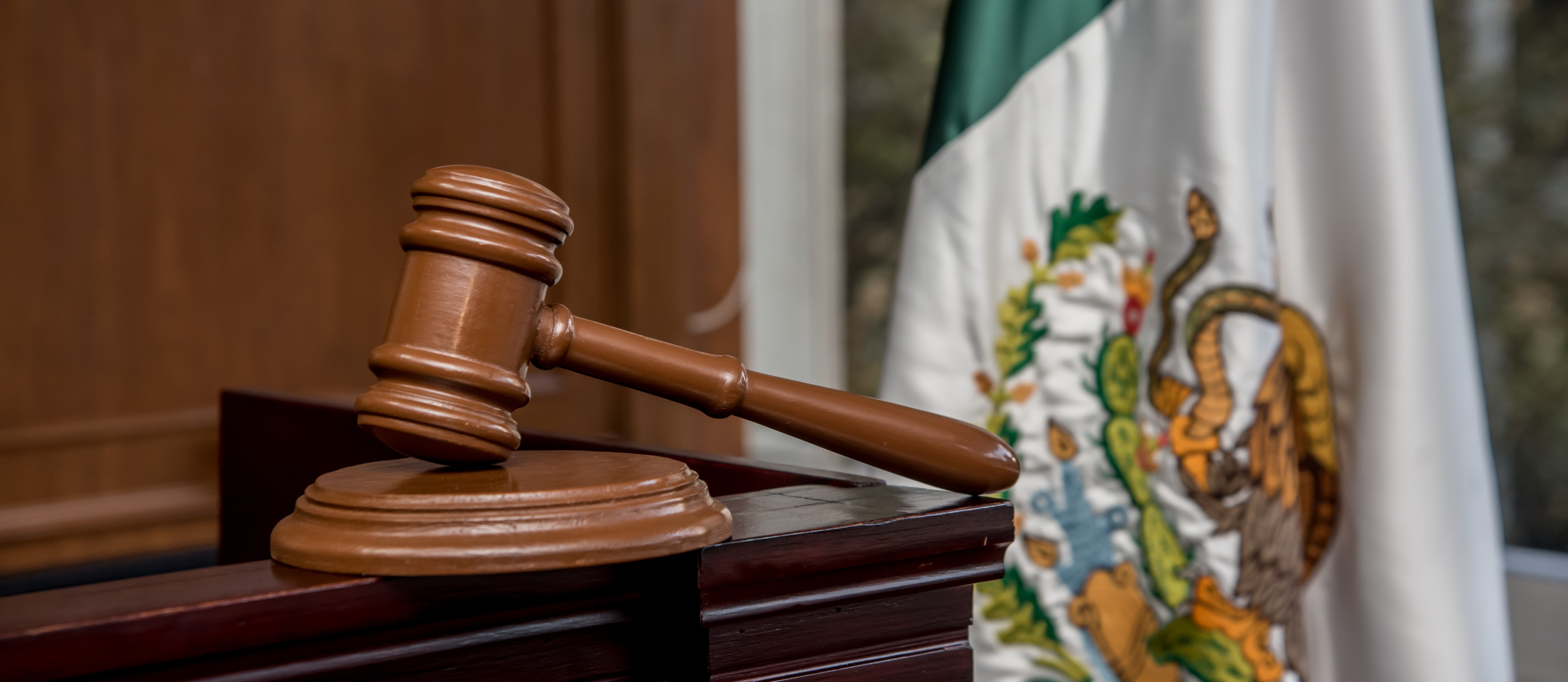 Gavel in a Mexican courtroom with flag in the background, symbolizing legal decisions on deduction limitation and tax regulations.
